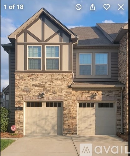 A house with a stone facade and two garage doors.