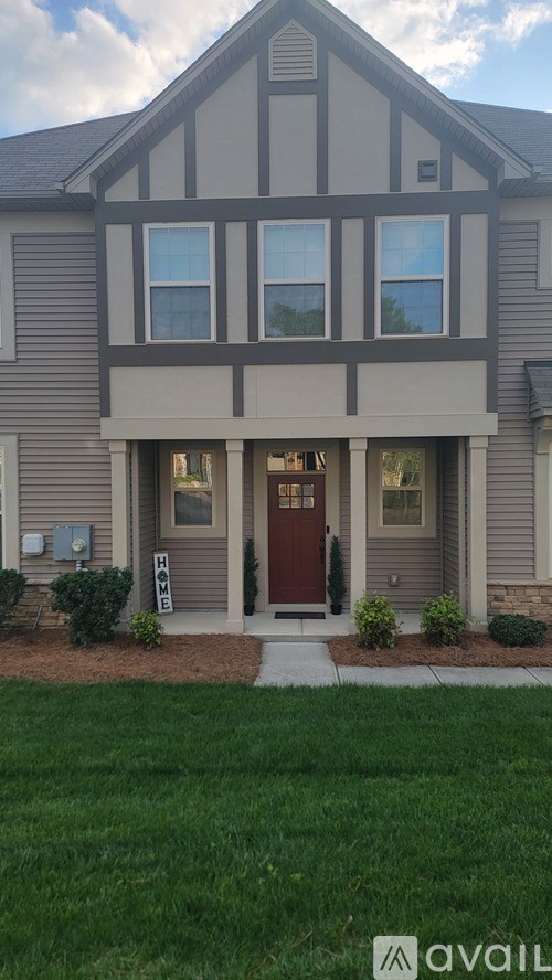 A house with a red door and a sign that says "For Sale".