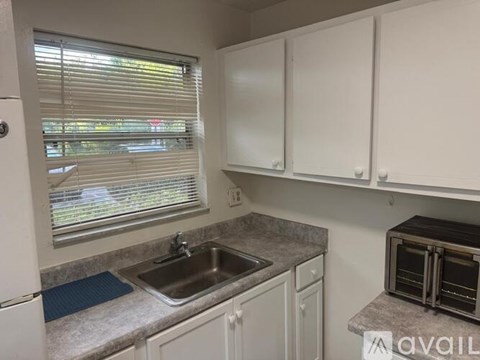 A kitchen with white cabinets and a granite countertop.