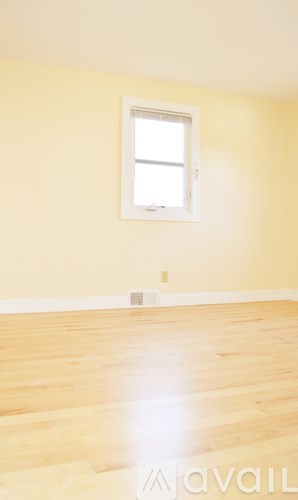 A room with a window and wooden flooring.