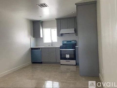 A kitchen with a dishwasher, sink, and cabinets.
