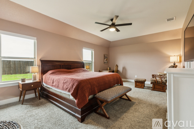 A bedroom with a large bed and a ceiling fan.