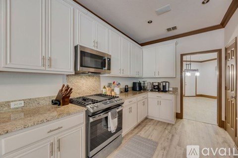 A kitchen with white cabinets and a granite countertop.