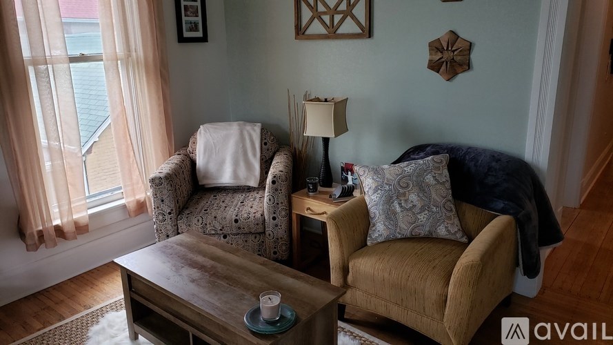 A living room with a sofa, armchair, and coffee table.