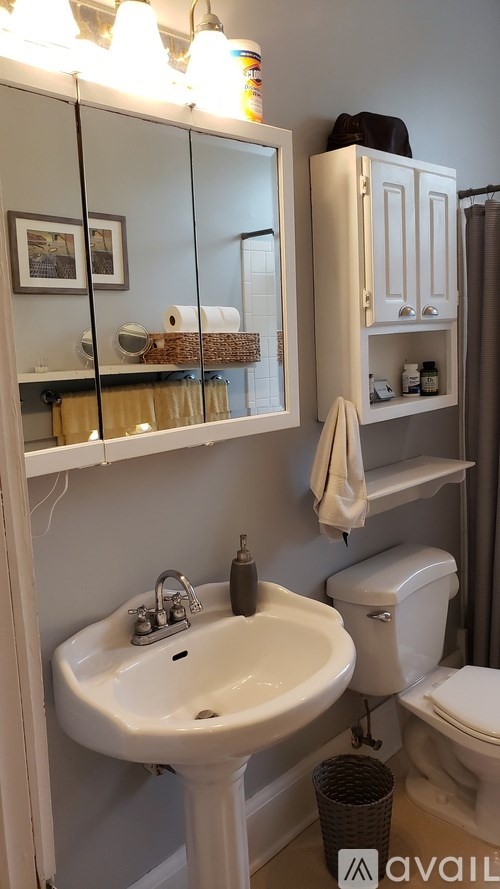 A bathroom with a white sink and toilet.