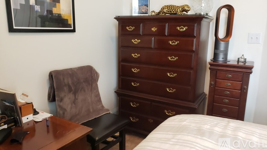 A brown chair sits in front of a brown desk with a computer on it.