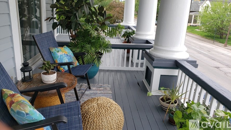 A balcony with a chair, table, and potted plants.