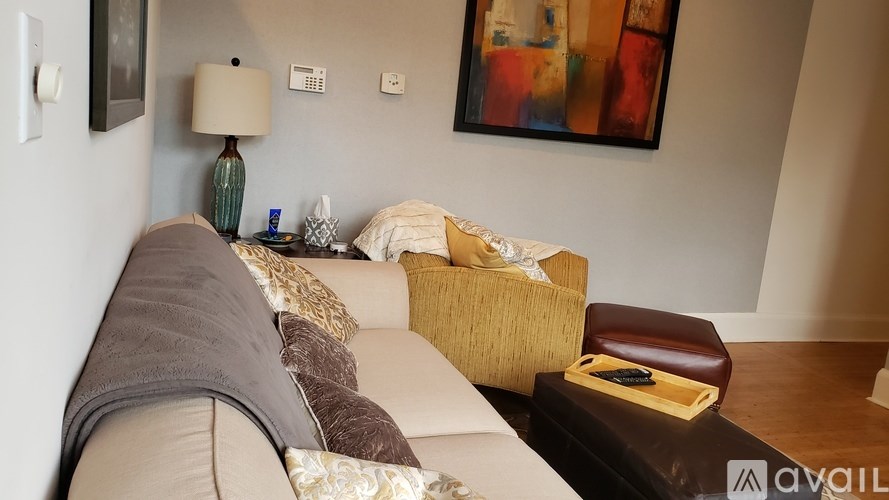 A living room with a couch, a lamp, and a painting on the wall.