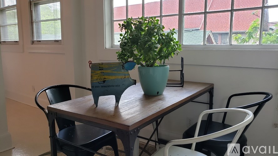 A table with a green pot and a blue pot on it with a sign on the table.