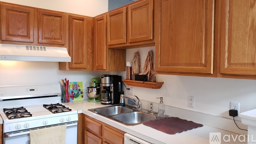 A kitchen with wooden cabinets and a white stove top oven.