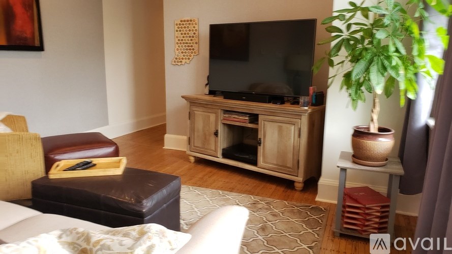 A living room with a television and a brown leather chair.