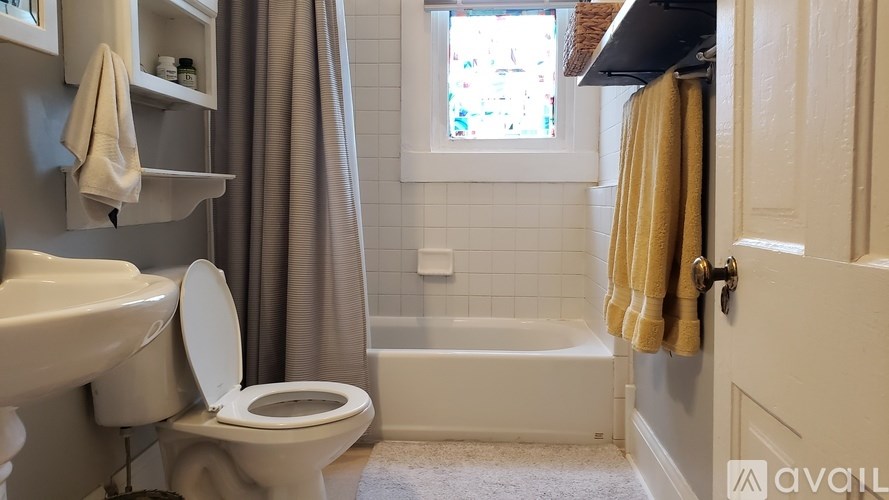 A bathroom with a toilet, sink, and bathtub.