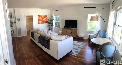A living room with a white couch and a television.