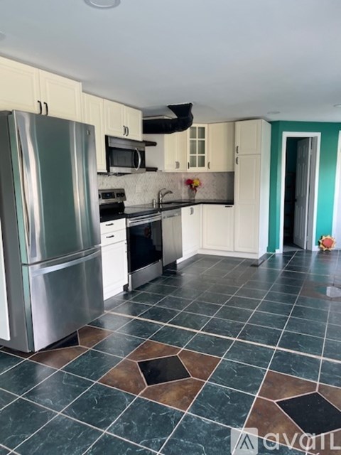 A kitchen with a refrigerator, oven, and microwave.