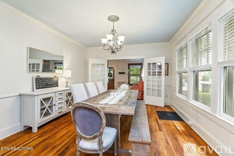 A dining room with a wooden table and chairs.