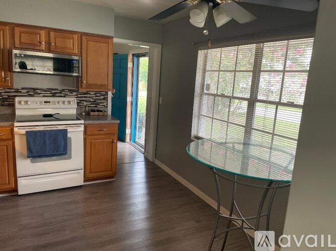 A kitchen with a white stove and wooden cabinets.