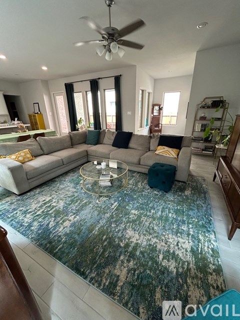 A living room with a grey sofa and a blue rug.