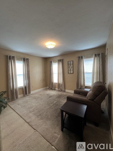 A living room with a brown chair and a brown ottoman.