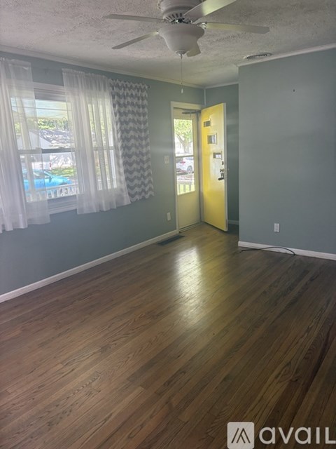 A room with wooden floors and a ceiling fan.