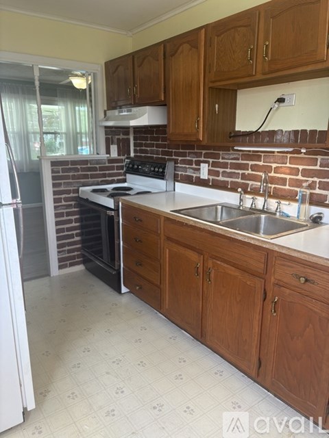A kitchen with wooden cabinets and a brick backsplash.