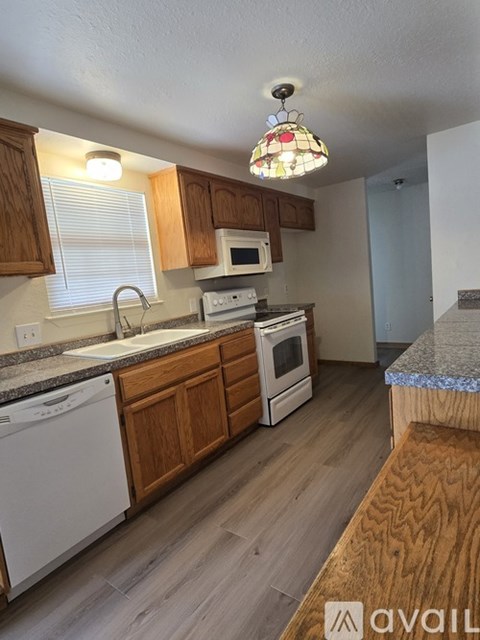 A kitchen with wooden cabinets and a white dishwasher.