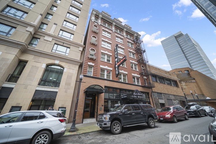 A street view of a building with cars parked in front.