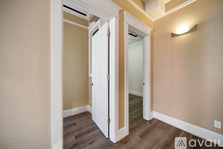 A room with a white door and a light on the wall.