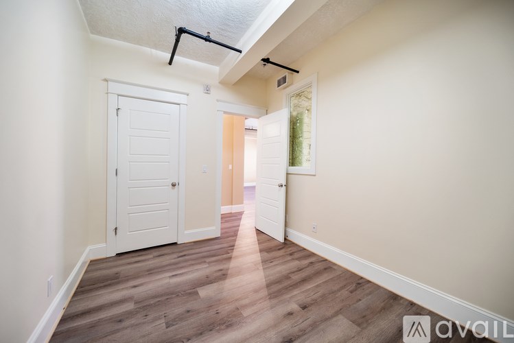 A room with a white door and a wooden floor.