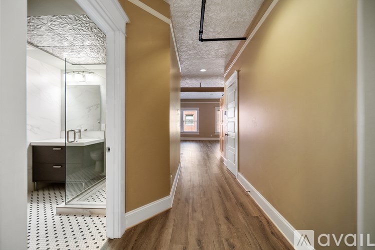 A hallway with a glass door and a tiled floor.