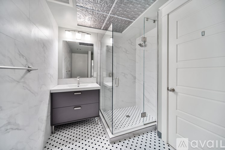 A bathroom with a marble wall and a white sink.