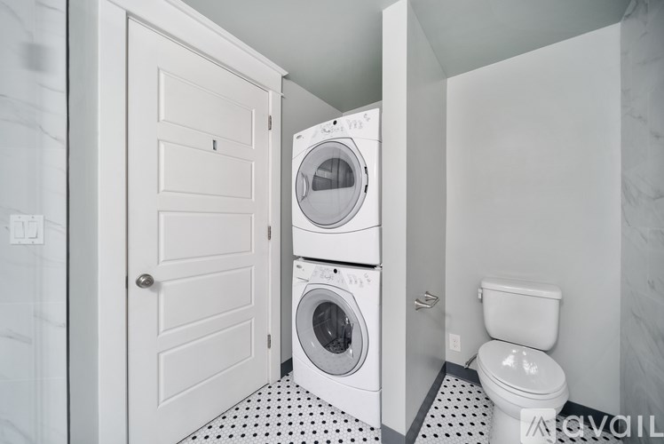 A small laundry room with a washer and dryer stacked on top of each other.