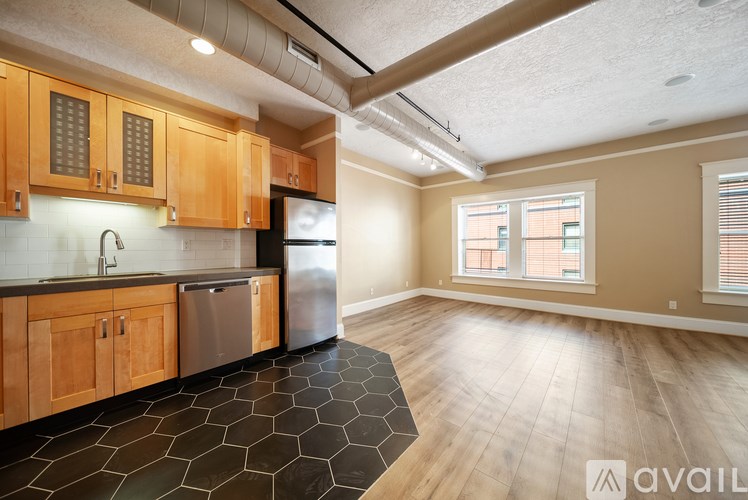 A kitchen with wooden cabinets and a black tile floor.