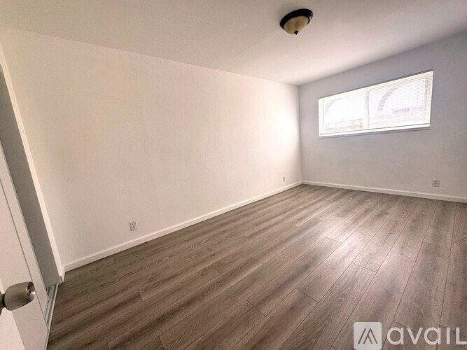 A room with wooden flooring and a window.