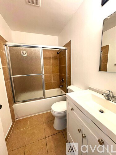 A bathroom with a toilet, sink, and shower.