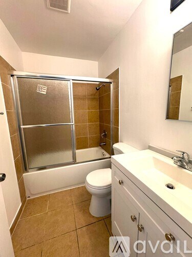 A bathroom with a toilet, sink, and shower.