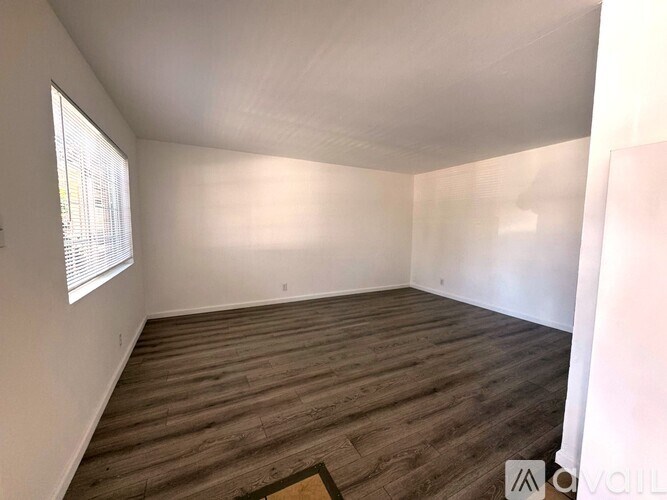 A room with wooden flooring and a window.