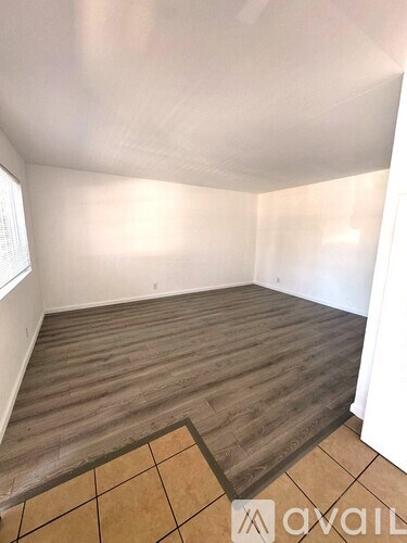 A room with wooden flooring and a tiled floor mat.