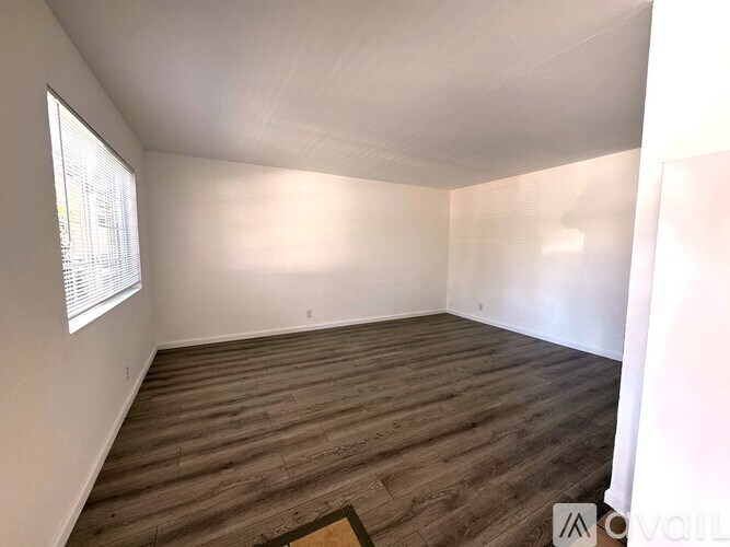 A room with wooden flooring and a window.