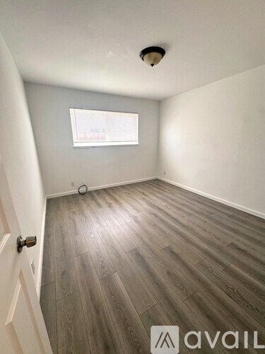 A room with wooden flooring and a window.