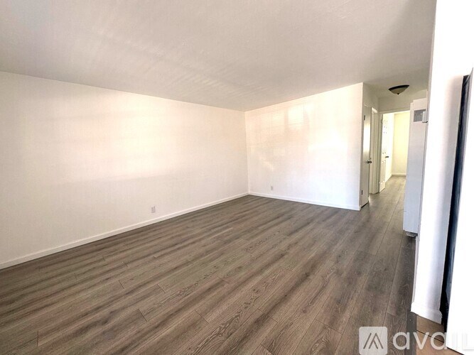 A room with wooden flooring and white walls.