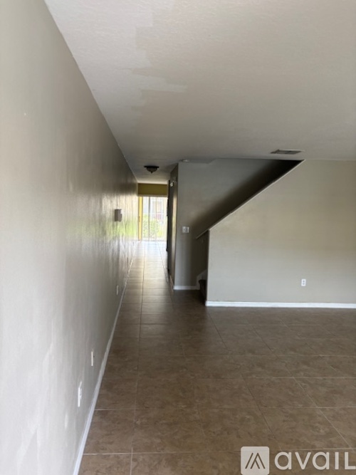 A long hallway with a tiled floor and white walls.