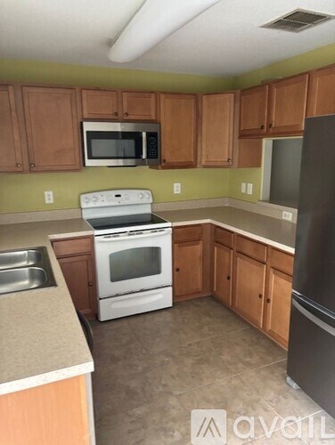 A kitchen with a white stove and wooden cabinets.