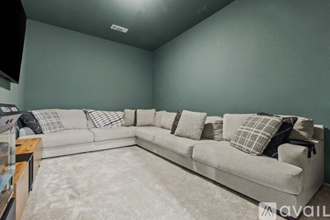 A living room with a grey couch and pillows.