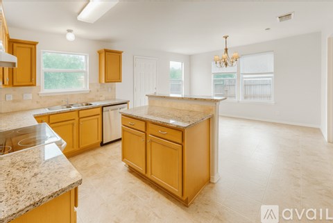 A kitchen with wooden cabinets and a marble countertop.