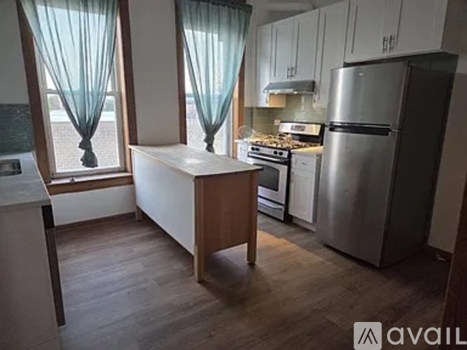 A kitchen with a refrigerator, stove, and sink.