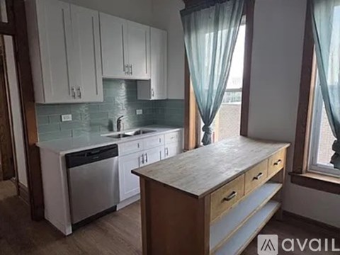 A kitchen with white cabinets and a wooden island.