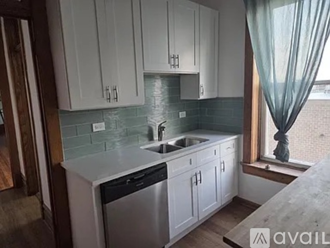 A kitchen with white cabinets and a green curtain.