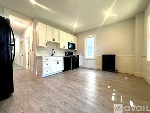 A kitchen with wooden floors and white cabinets is available for rent.