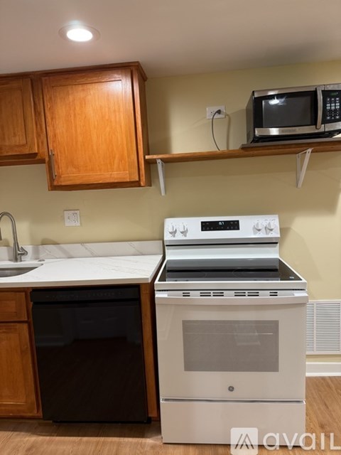 A kitchen with a white oven and a black dishwasher.