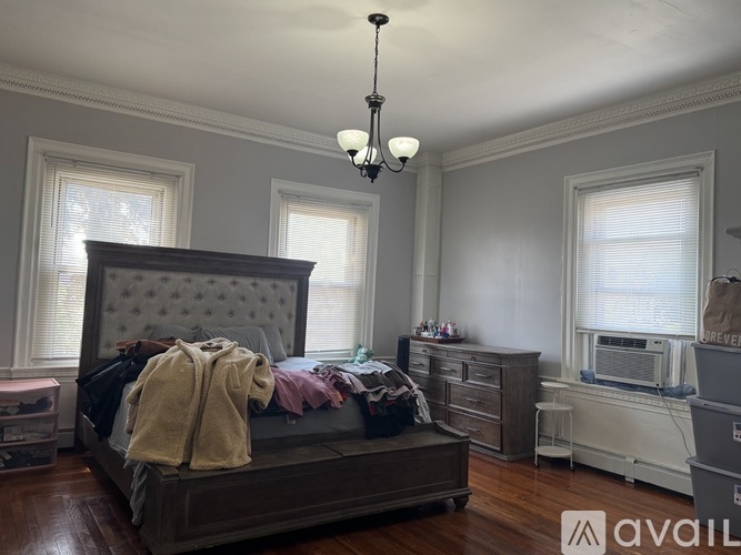 A bedroom with a large bed and a chandelier.